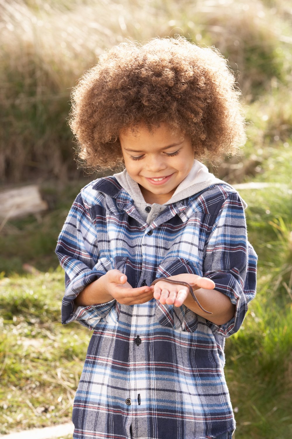 A boy holding a worm